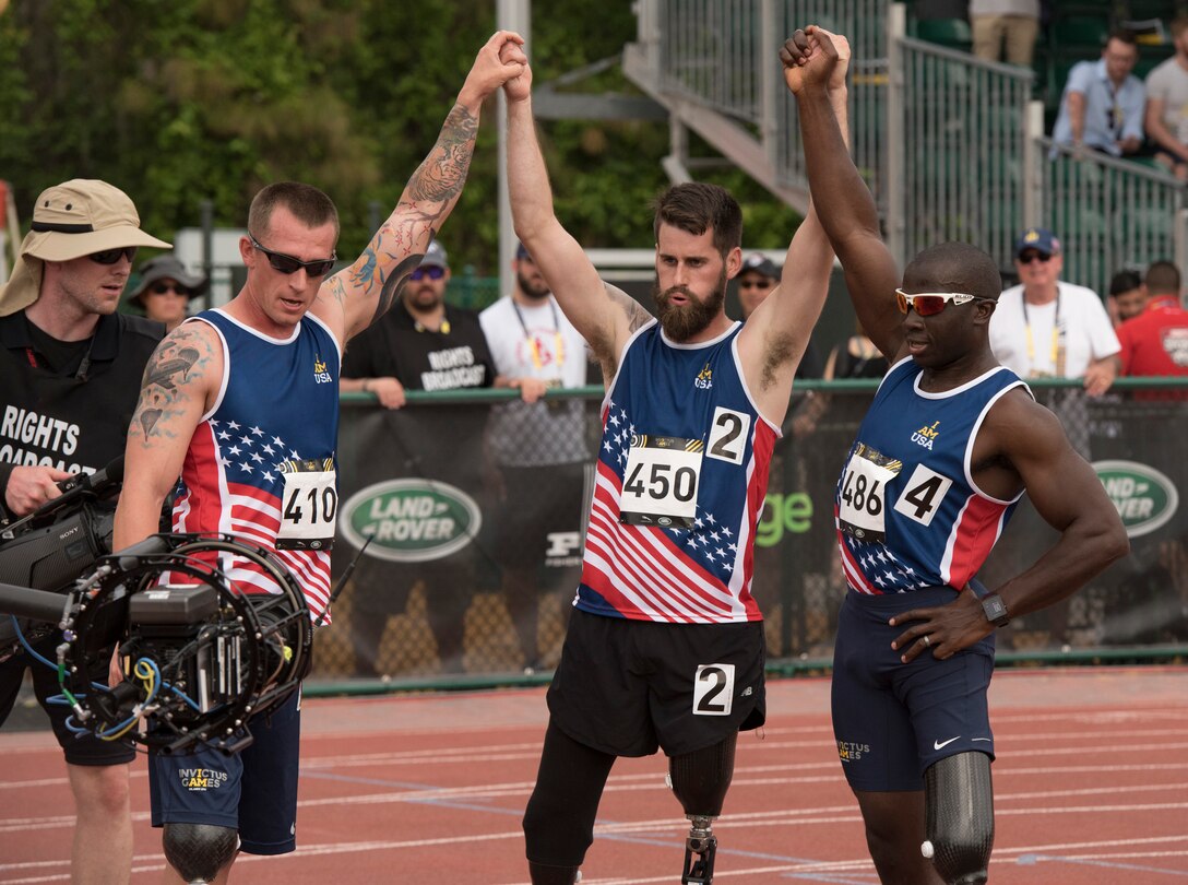 From left, Army Sgt. 1st Class Allan Armstrong, Army veteran Stefan LeRoy and Army veteran William Reynolds celebrate after their 1,500-meter race during the 2016 Invictus Games in Orlando, Fla., May 10, 2016. DoD photo by Roger Wollenberg