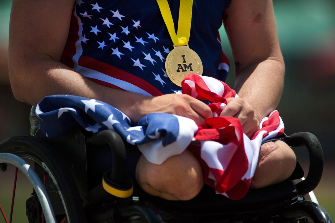 A member of the U.S. team holds an American flag after winning a gold medal during the 2016 Invictus Games in Orlando, Fla., May 10, 2016. DoD photo by EJ Hersom