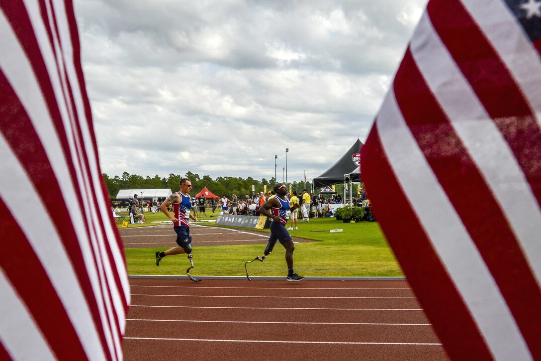 Army veteran William Reynolds, right, leads a pack of runners as Army Sgt. 1st Class Allan Armstrong runs in close second during a 1,500-meter race at the 2016 Invictus Games in Orlando, Fla., May 10, 2016. Air Force photo by Senior Master Sgt. Kevin Wallace 