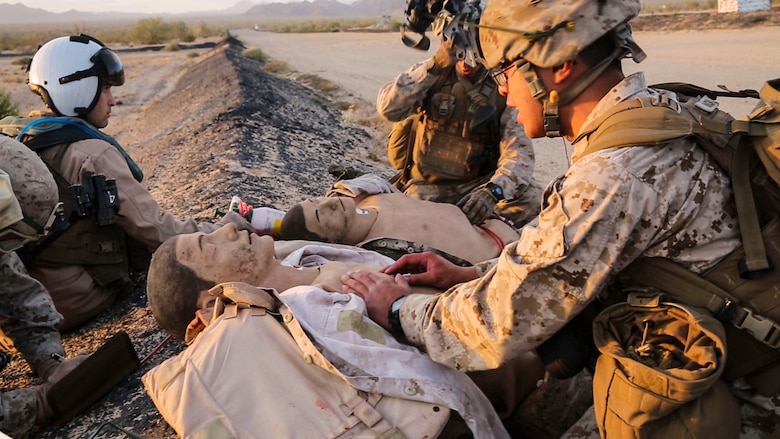 Service members from 1st Marine Division apply first aid to simulated casualties during a Tactical Recovery of Aircraft and Personnel mission in El Centro, Calif., April 28. The TRAP mission was a part of a Marine Air-Ground Task Force Integration Exercise with units from Marine Aircraft Group (MAG) 39 as a part of MAG-39’s new MAGTF integration effort. (U.S. Marine Corps photo by Sgt. Brian Marion/Released)