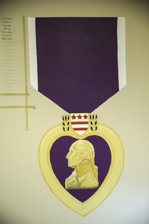Painted on a wall inside Combat Logistics Battalion 2’s headquarters building stands a 7.5-foot-tall rendition of the Purple Heart Medal, one of the most recognized and respected medals awarded to members of the U.S. armed forces. Lance Cpl. Ashley Tichensky, a motor-transportation operator with Transportation Services Company, Combat Logistics Battalion 2, spent roughly 15 hours drawing and painting a replica of the medal to represent her battalion’s Marines who have been awarded this military decoration during their service. (U.S. Marine Corps photo by Cpl. Kaitlyn V. Klein/Released)