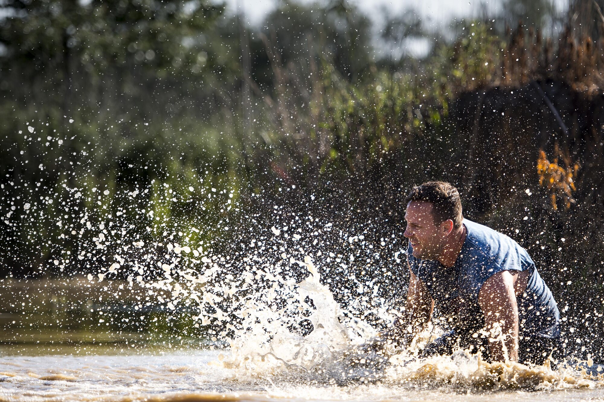 A runner splashes into a pond during the 2016 Moody Mudder, May 7, 2016, in Ray City, Ga. The Mudder challenged nearly 500 competitors to complete 20 obstacles on a 3.12-mile course for the third year in a row. (U.S. Air Force photo by Senior Airman Ryan Callaghan/Released)