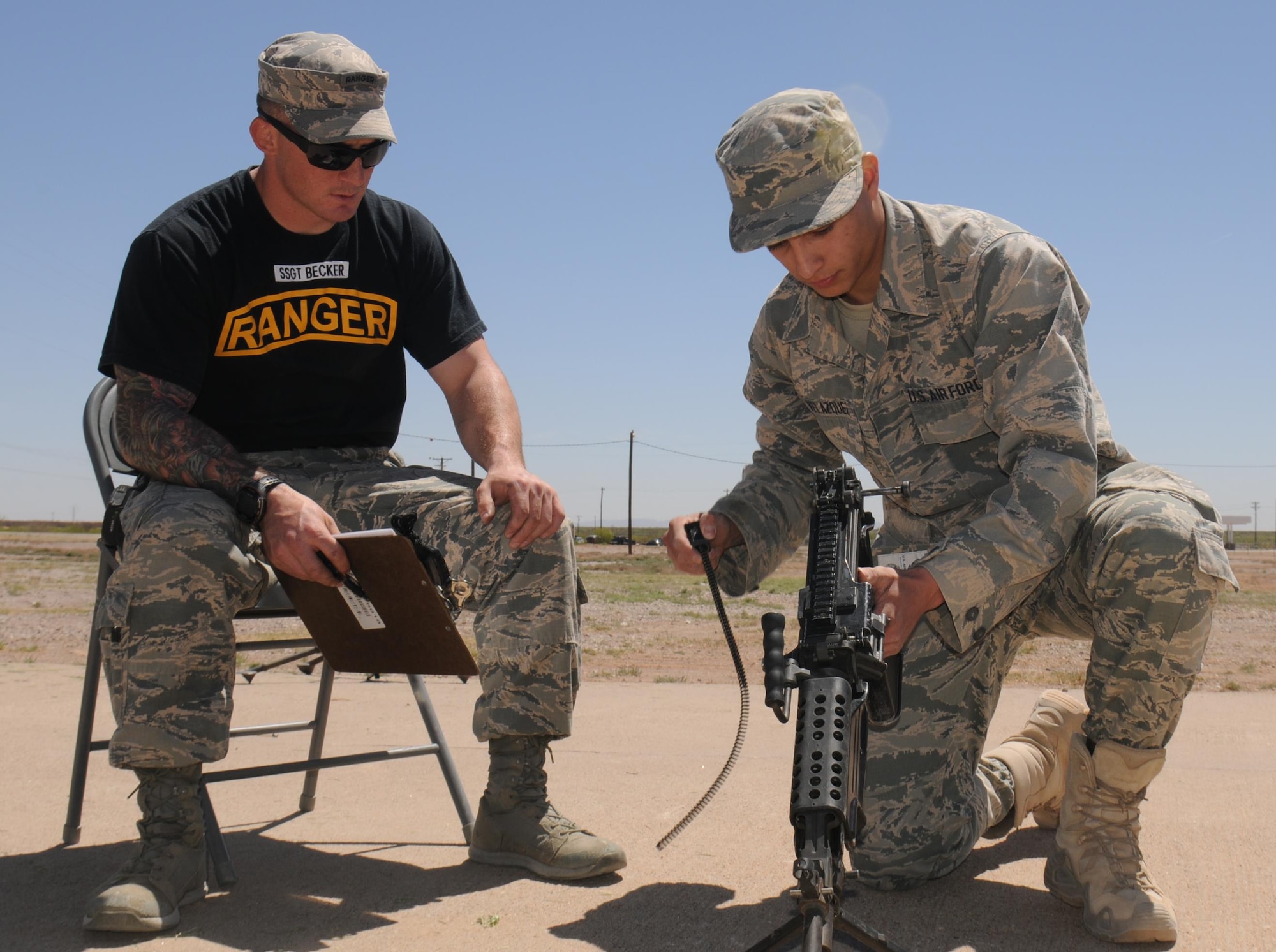 Air Force Staff Sgt. Stephen Becker, a Ranger instructor, watches Airman 1st Class Jonathan Velazquez reassemble a M249 light machine gun April 20, 2016, during an Air Force Security Forces Center Ranger assessment course at the Dona Ana Range, New Mexico. (U.S. Army photo/Staff Sgt. Corey Baltos)