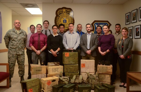 Air Force Office of Special Investigations detachment 206, stands behind ceased material after successfully completing a case during 2015 at Nellis Air Force Base, Nev. During 2015, det. 206 ran 125 cases in which they would cease stolen material, conduct busts and would receive confessions for crimes. For their actions, det. 206 was recognized as the best large Air Force OSI detachment. (Courtesy photo)