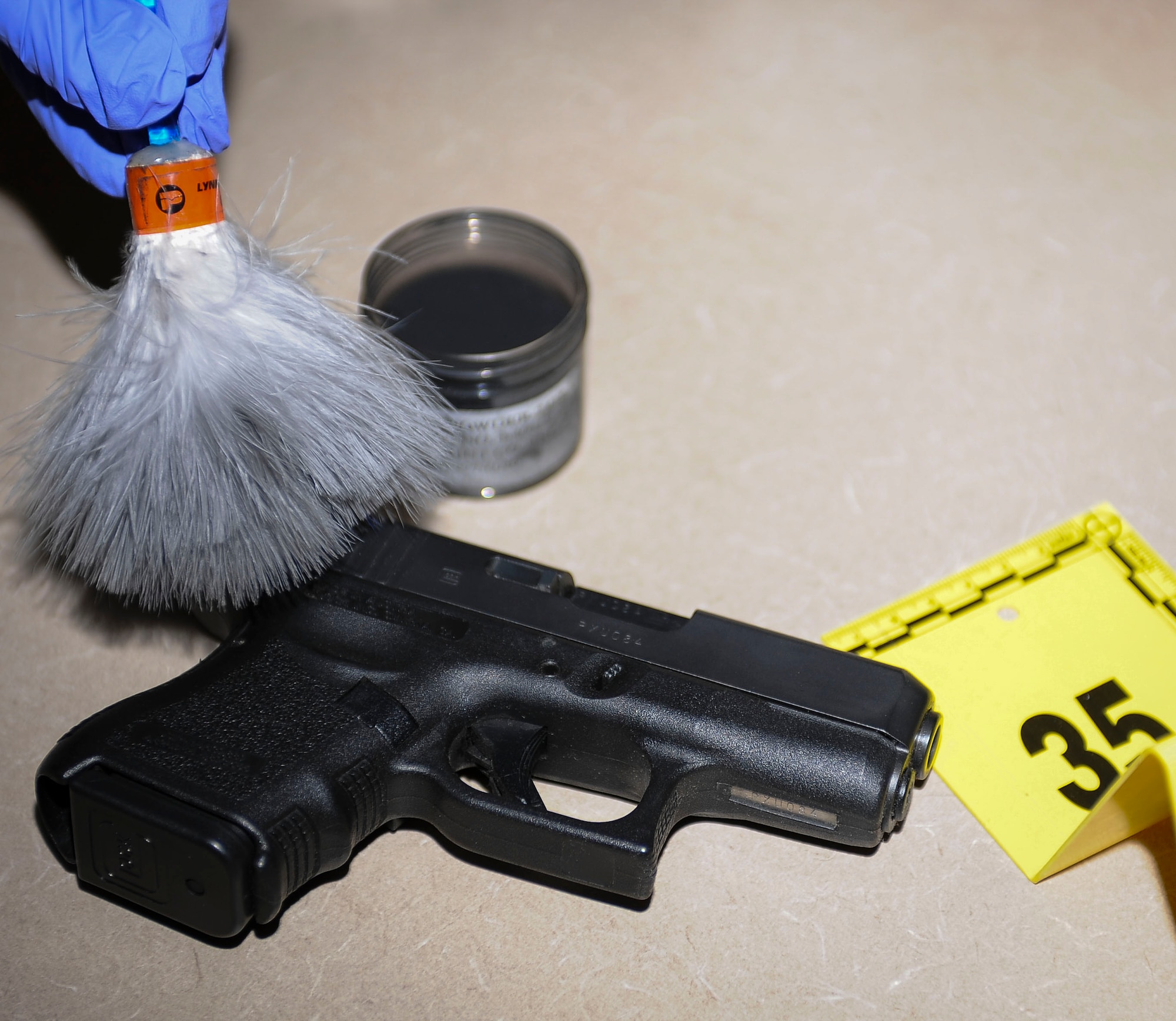 Special Agent Ashley Rivera, Air Force Office of Special Investigations detachment 206, criminal investigator, dusts a handgun for fingerprints May 2, 2016 at Nellis Air Force Base, Nev. For 2015, det. 206 was recognized as the best large Air Force OSI detachment after saving the Air Force millions of dollars. (U.S. Air Force photo by Senior Airman Jake Carter)