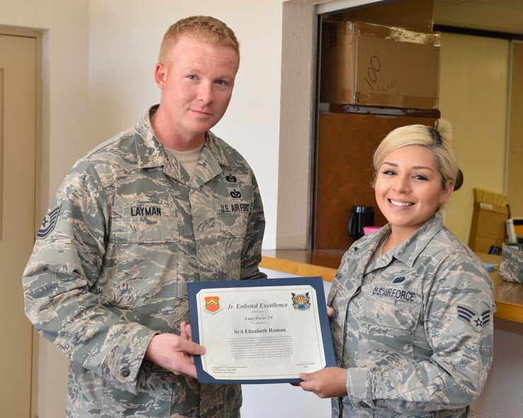 Tech. Sgt. Brandon Layman, Luke Focus 56 president, presents Senior Airman Elizabeth Roman, 56th Communication Squadron infrastructure technician, with the Luke Focus 56 Junior Enlisted Excellence award April 13, 2016 at Luke Air Force Base, Ariz. Roman used Self Aid Buddy Care to save a man that was stuck by a vehicle. (U.S. Air Force photo by Senior Airman James Hensley)