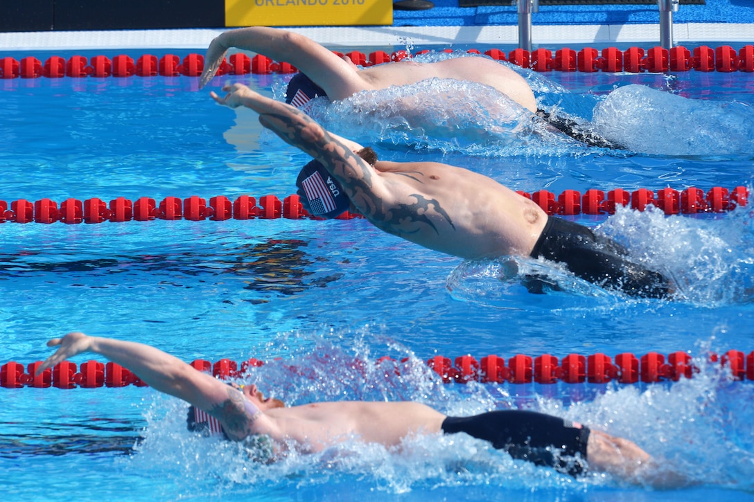 Marine Corps Maj. Peter Cook, top, Air Force veteran Leonard Anderson, middle, and Marine Corps veteran Evan Stratton compete in the 50-meter backstroke event at the 2016 Invictus Games in Orlando, Fla., May 11, 2016. Army photo by Staff Sgt. Alex Manne