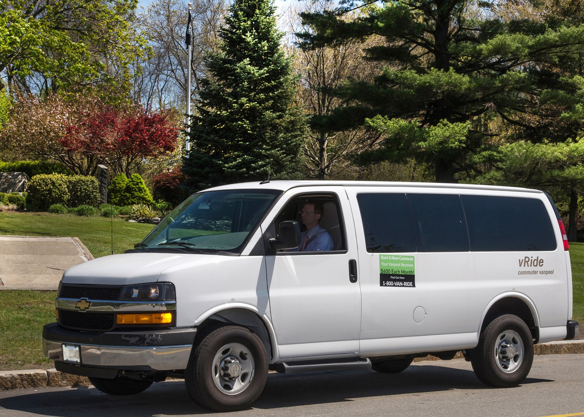 Lance Beebe drives a vRide commuting van down Grenier Street on base May 11 to pick up other riders. The United States Environmental Protection Agency recognized Scott Sheehan, an environmental engineer with the 66th Civil Engineering Division, with an environmental award for his efforts with the base’s commuter program. (U.S. Air Force photo by Walter Santos)