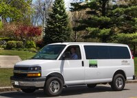 Lance Beebe drives a vRide commuting van down Grenier Street on base May 11 to pick up other riders. The United States Environmental Protection Agency recognized Scott Sheehan, an environmental engineer with the 66th Civil Engineering Division, with an environmental award for his efforts with the base’s commuter program. (U.S. Air Force photo by Walter Santos)