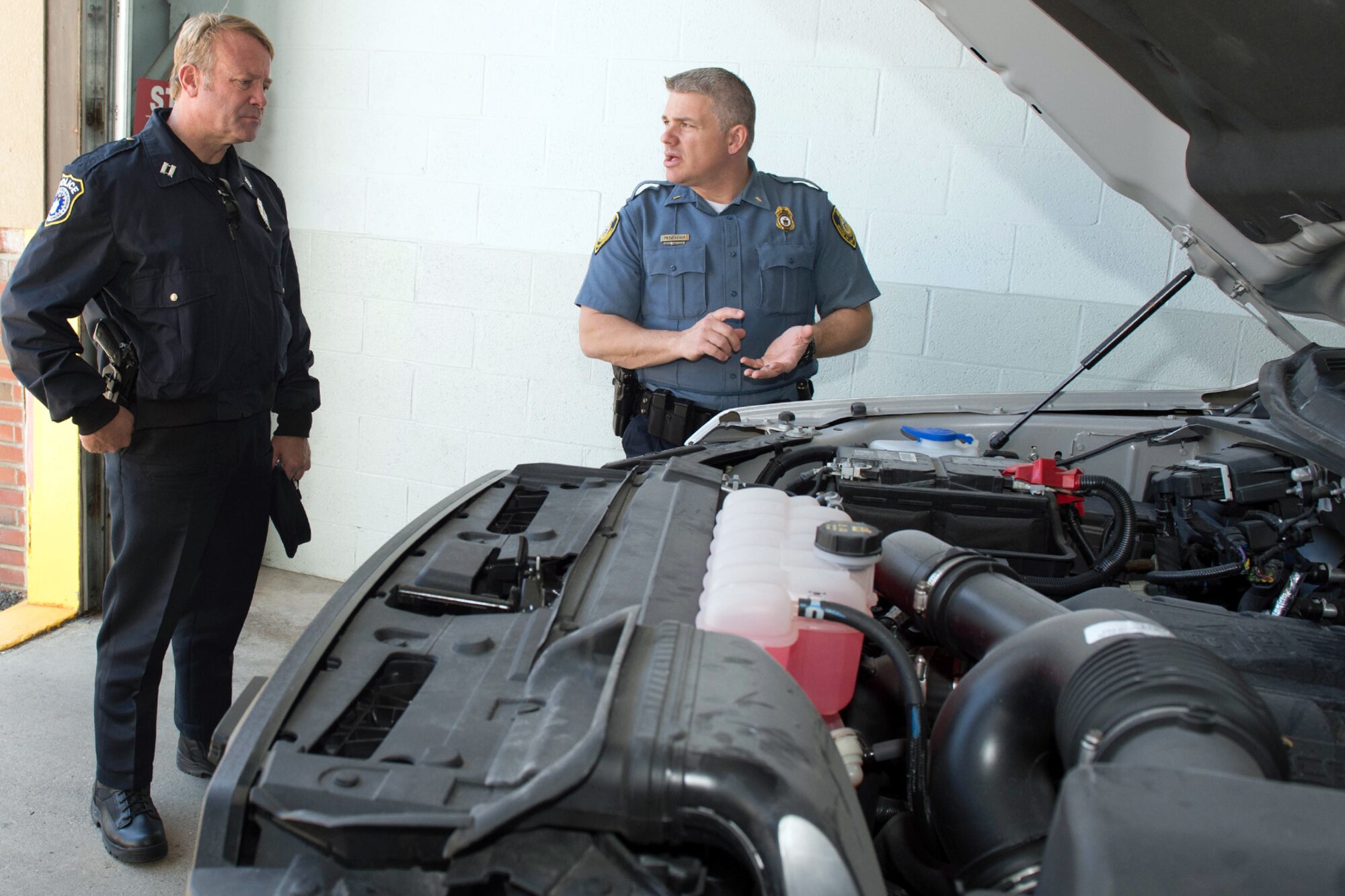 Albert Blais, 66th Security Forces Squadron program chief for civilian police force, speaks with Lt. Eric Provencher, National Oceanic and Atmospheric Administration officer, during the 66th Logistics Readiness Squadron’s open house on base May 10. During the event, Government Service Agency motor vehicle managers answered questions about government-leased vehicles and showed some of the electric, hybrid and fuel-efficient vehicles. (U.S. Air Force photo by Jerry Saslav)