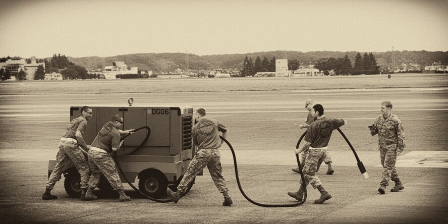 A team from the 730th Air Mobility Squadron rolls up a power cable during a relay race for the 730 AMS Maintenance Rodeo at Yokota Air Base, Japan, May 6, 2016. Six teams participated in the rodeo which had a variety of challenges: tool box inventory, safety wire skill, vehicle tow bar push, power cart relay race and Mission Oriented Protective Postures (MOPP) gear and Self Aid Buddy Care (SABC) timed event. (U.S. Air Force photo by Yasuo Osakabe/Released) 