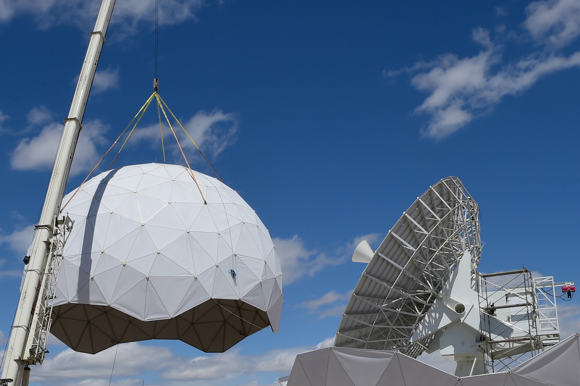 A crane removes the protective geodesic radar dome April 27, 2016, on Buckley Air Force Base, Colo. The 460th Communications Squadron and the 460th Civil Engineer Squadron are working with Radome Services LLC to replace the existing antenna with a new, more technologically advanced antenna that can better communicate with newer satellites. (U.S. Air Force photo by Airman 1st Class Luke W. Nowakowski/Released) 
