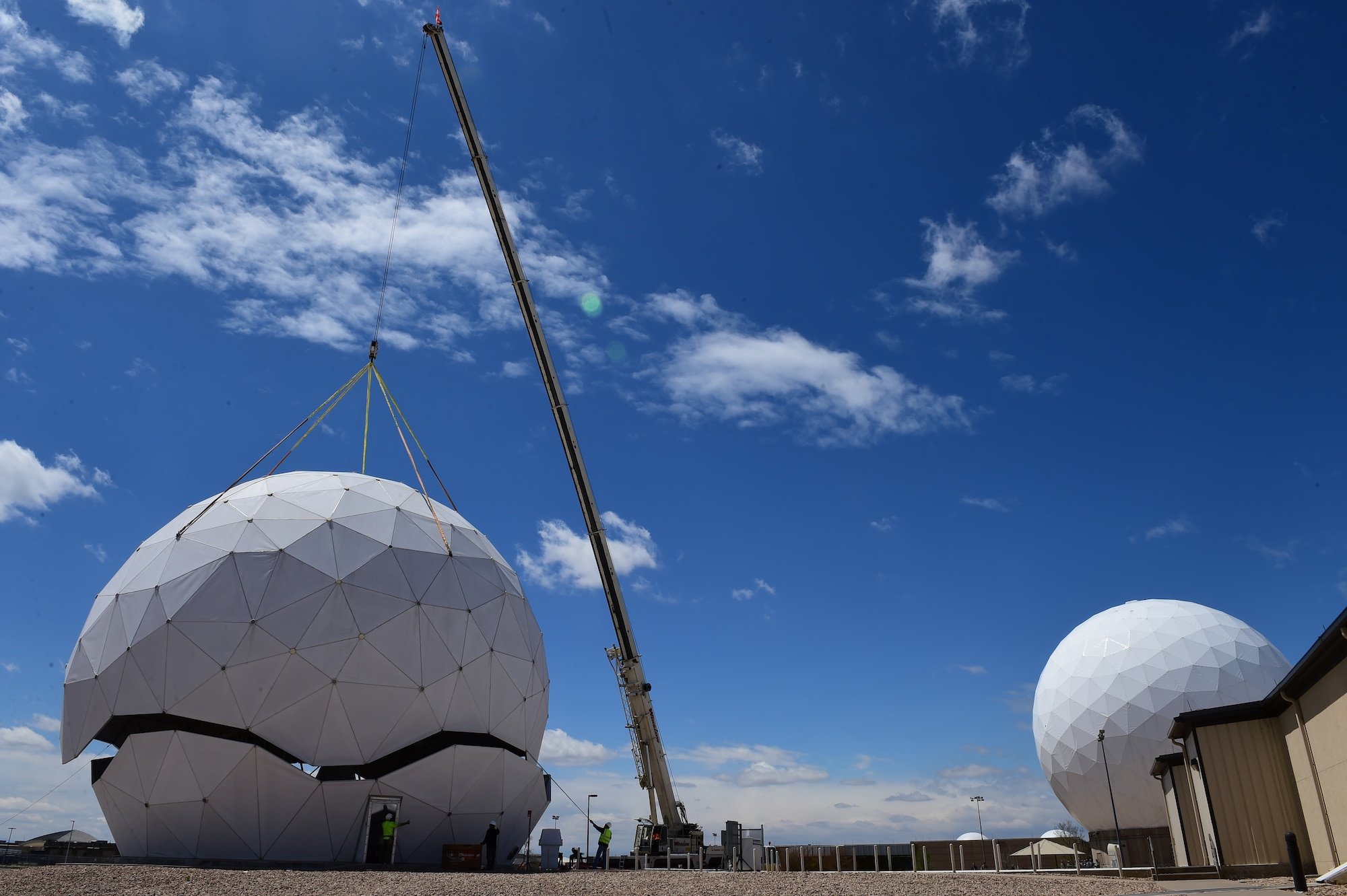 A crane removes the protective geodesic radar dome April 27, 2016, on Buckley Air Force Base, Colo. The 460th Communications Squadron and the 460th Civil Engineer Squadron are working with Radome Services LLC to replace the existing antenna with a new, more technologically advanced antenna that can better communicate with newer satellites. (U.S. Air Force photo by Airman 1st Class Luke W. Nowakowski/Released) 