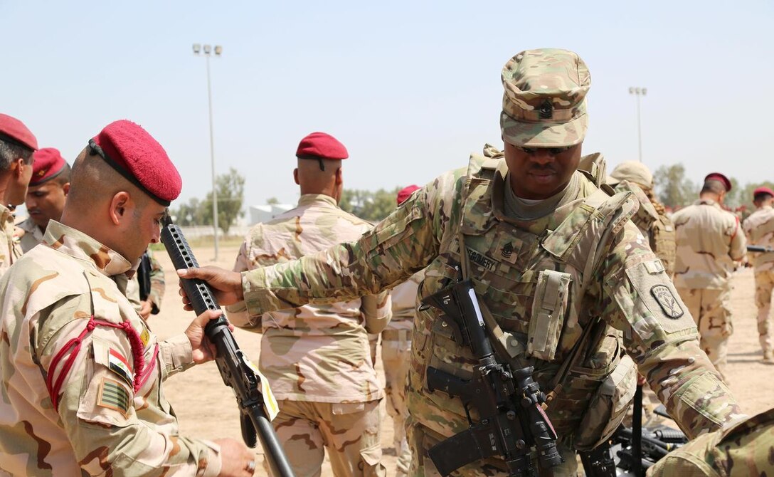 Army 1st Sgt. Gabriel Montgomery with 524th Combat Sustainment Support Battalion, 17th Sustainment Brigade, Task Force Battle Born, issues an M-16 rifle to an Iraqi soldier assigned to Iraq’s 4th Battalion, 23rd Brigade, during an Iraqi Train and Equip Fund issuing point at Camp Taji, Iraq, April 16, 2016. (Army photo by Sgt. Kalie Jones)