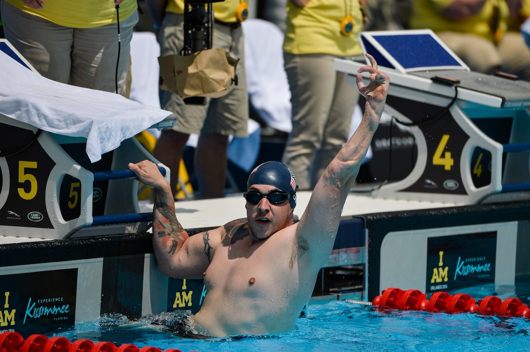 Army veteran Tim Payne raises celebrates after winning the 100-meter freestyle event at the 2016 Invictus Games in Orlando, Fla., May 11, 2016. Air Force photo by Tech. Sgt. Joshua L. DeMotts