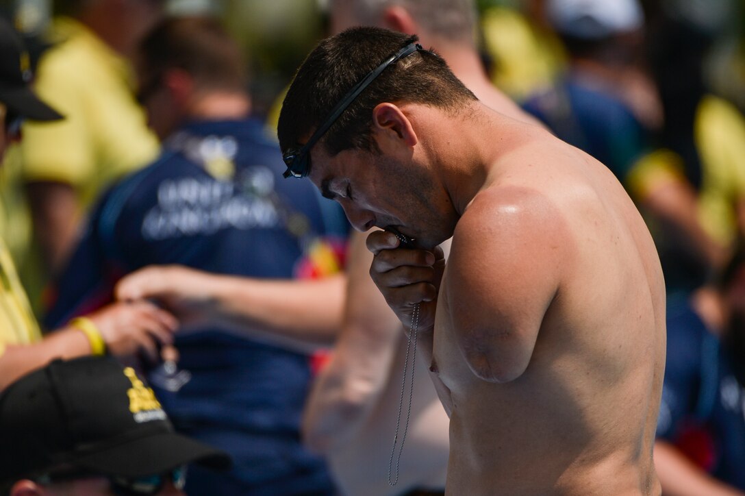 Army veteran Michael Kacer kisses his dog tags before competing in the 100-meter freestyle event at the 2016 Invictus Games in Orlando, Fla., May 11, 2016. Air Force photo by Tech. Sgt. Joshua L. DeMotts