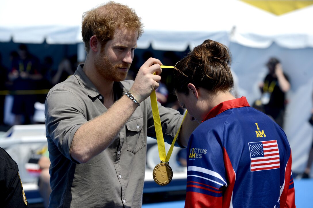 Prince Harry presents a gold medal to U.S. Army Sgt. Elizabeth Marks at the 2016 Invictus Games in Orlando, Fla., May 11, 2016. Marks won the gold medal with a time of 42:67 seconds. Air Force photo by Staff Sgt. Carlin Leslie 