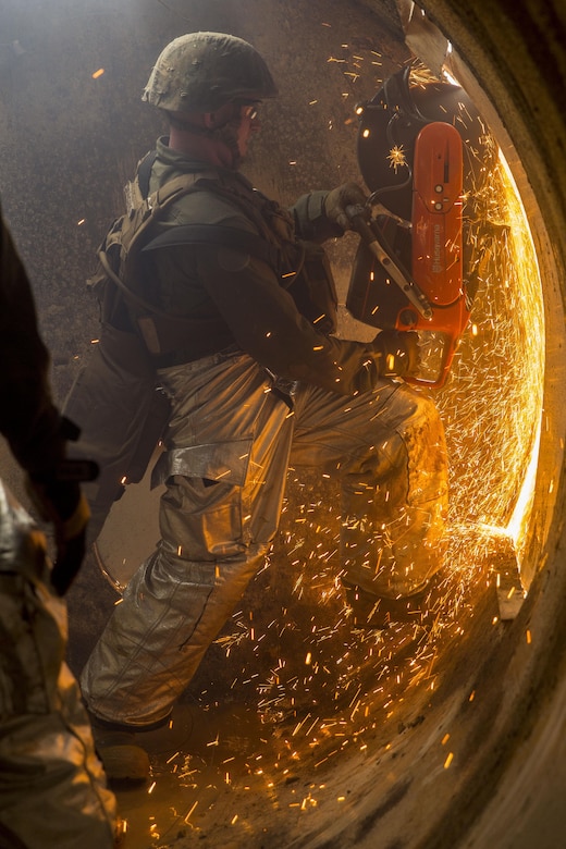 Sgt. Micah Steven McMackins, an aircraft rescue and firefighting specialist with Headquarters and Headquarters Squadron saws through the wall of a simulated aircraft as part of the aircraft salvage and recovery operations during exercise Thunder Horse 16.2 at the Japan Ground Self-Defense Force’s Haramura Maneuver Area in Hiroshima, Japan, May 11, 2016. Motor transportation operators, combat engineers, heavy equipment operators and aircraft rescue and firefighters worked together to recover the simulated downed aircraft. The exercise focuses on reinforcing skills that Marines learned during Marine Combat Training and throughout their military occupational specialty schooling in order to maintain situational readiness. (U.S. Marine Corps photo by Lance Cpl. Aaron Henson/Released)