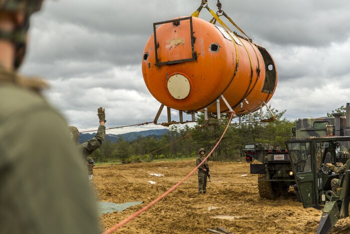 Marines with aircraft rescue and firefighting, Headquarters and Headquarters Squadron, guide a simulated aircraft to the back of a 7-ton medium tactical vehicle replacement during exercise Thunder Horse 16.2 at the Japan Ground Self-Defense Force’s Haramura Maneuver Area in Hiroshima, Japan, May 11, 2016. Motor transportation operators, combat engineers, heavy equipment operators and aircraft rescue and firefighters worked together to recover the simulated downed aircraft. The exercise focuses on reinforcing skills that Marines learned during Marine Combat Training and throughout their military occupational specialty schooling in order to maintain situational readiness. The opportunity to train in this environment helps Marines within different squadrons enhance their technical skills, field experience and military occupational specialty capabilities. (U.S. Marine Corps photo by Lance Cpl. Aaron Henson/Released)