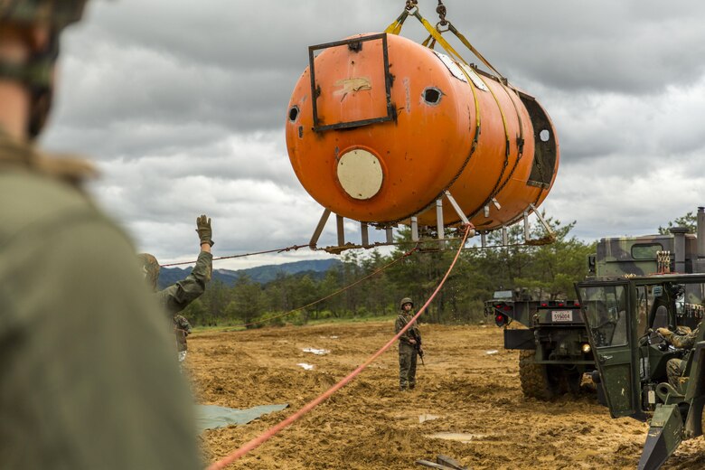 Marines with aircraft rescue and firefighting, Headquarters and Headquarters Squadron, guide a simulated aircraft to the back of a 7-ton medium tactical vehicle replacement during exercise Thunder Horse 16.2 at the Japan Ground Self-Defense Force’s Haramura Maneuver Area in Hiroshima, Japan, May 11, 2016. Motor transportation operators, combat engineers, heavy equipment operators and aircraft rescue and firefighters worked together to recover the simulated downed aircraft. The exercise focuses on reinforcing skills that Marines learned during Marine Combat Training and throughout their military occupational specialty schooling in order to maintain situational readiness. The opportunity to train in this environment helps Marines within different squadrons enhance their technical skills, field experience and military occupational specialty capabilities. (U.S. Marine Corps photo by Lance Cpl. Aaron Henson/Released)
