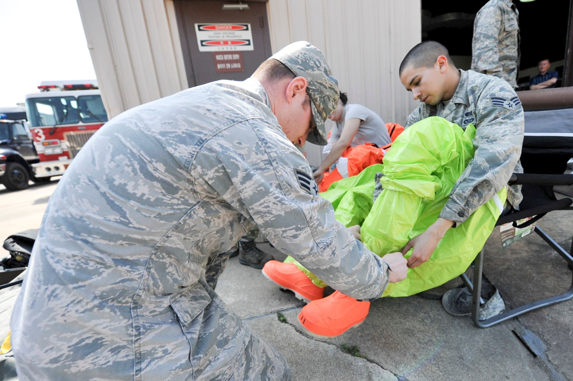 Senior Airman Mathew Ghara, 51st Civil Engineer Squadron emergency management journeyman, helps Senior Airman Mathew Castellanos, 51st CES emergency management journeyman, put on a level A HAZMAT suit during Exercise Beverly Herd 16-01 at Osan Air Base, Republic of Korea May 12, 2016. Ghara and Castellanos were responding to a mock chemical improvised explosive device to test and identify the substance. (U.S. Air Force photo by Staff Sgt. Jonathan Steffen/Released) 