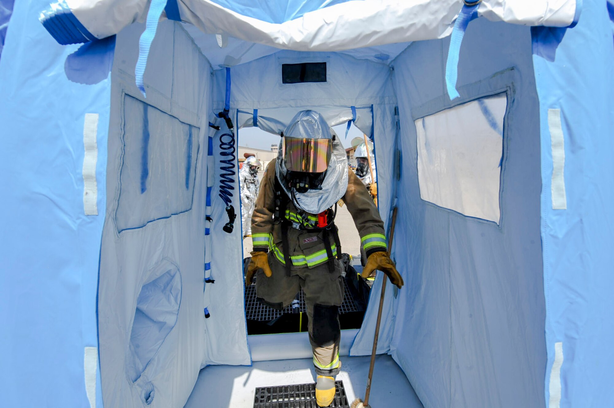 A firefighter from the 51st Civil Engineer Squadron enters the portable shower on a decontamination line after responding to a mock chemical improvised explosive device during Exercise Beverly Herd 16-01 at Osan Air Base, Republic of Korea, May 12, 2016. The decontamination line allows personnel leaving a hazardous area to be properly cleaned. (U.S. Air Force photo by Staff Sgt. Jonathan Steffen/Released)