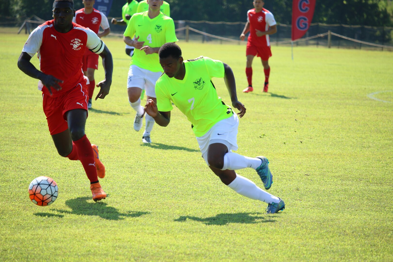 Petty Officer 2nd Class Kyle Baker (Yellow #7) drives down the field against Marine Cpl. Adrian Brown (left). Baker scored the go ahead goal lifting Navy over the Marines for the 2-1 win in match five of the 2016 Armed Forces Men's Soccer Championship hosted at Fort Benning, Ga from 6-14 May 2016.  Navy advances to the Championship Match versus Air Force.