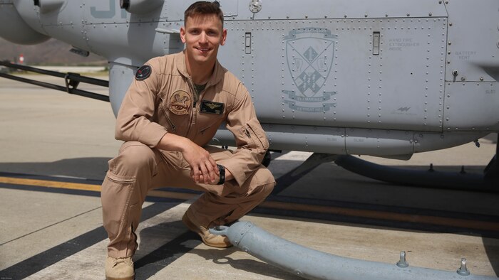 Capt. Jason Grimes, an AH-1Z Cobra pilot with Marine Light Attack Helicopter Squadron 369, poses next to the logo for 2nd Battalion, 5th Marine Regiment, painted on the side of a Cobra aboard Marine Corps Air Station Camp Pendleton, Calif., April 26, 2016. Squadrons with Marine Aircraft Group 39 are partnered with ground units from 1st Marine Division to build stronger relationships as a part of MAG-39’s new integration effort, 