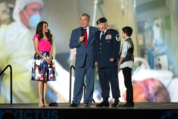 Former President George W. Bush stands on stage with Master Sgt. Israel Del Toro and his family and speaks during the opening ceremony of the 2016 Invictus games in Orlando, Fla., May 8, 2016. (Defense Department photo/EJ Hersom)
