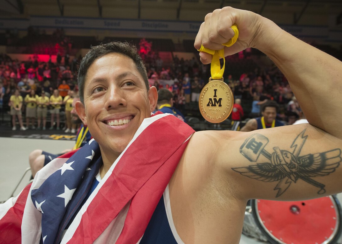Marine Corps veteran Anthony Rios shows off his gold medal after the U.S. defeated Denmark in wheelchair rugby during the 2016 Invictus Games in Orlando, Fla., May 11, 2016. DoD photo by Roger Wollenberg