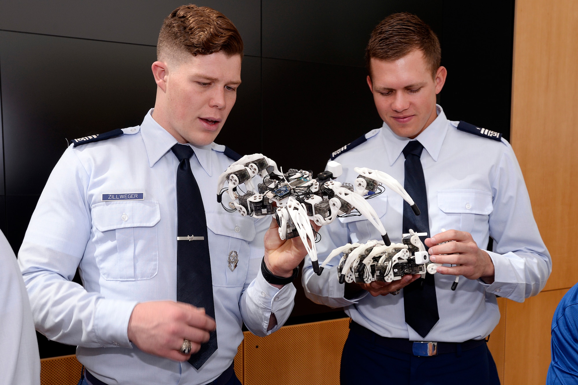 Cadets 1st Class Nathanael Zillweger and Steven Trojan hold "Spider Bots" May 1, 2016 at the Disruptive Technology Exhibit hosted by the U.S. Air Force Academy. The robots were programmed to simultaneously dance to a Bruno Mars song. The exhibit took place April 31-May 1, 2016. (U.S. Air Force photo/Mike Kaplan) 