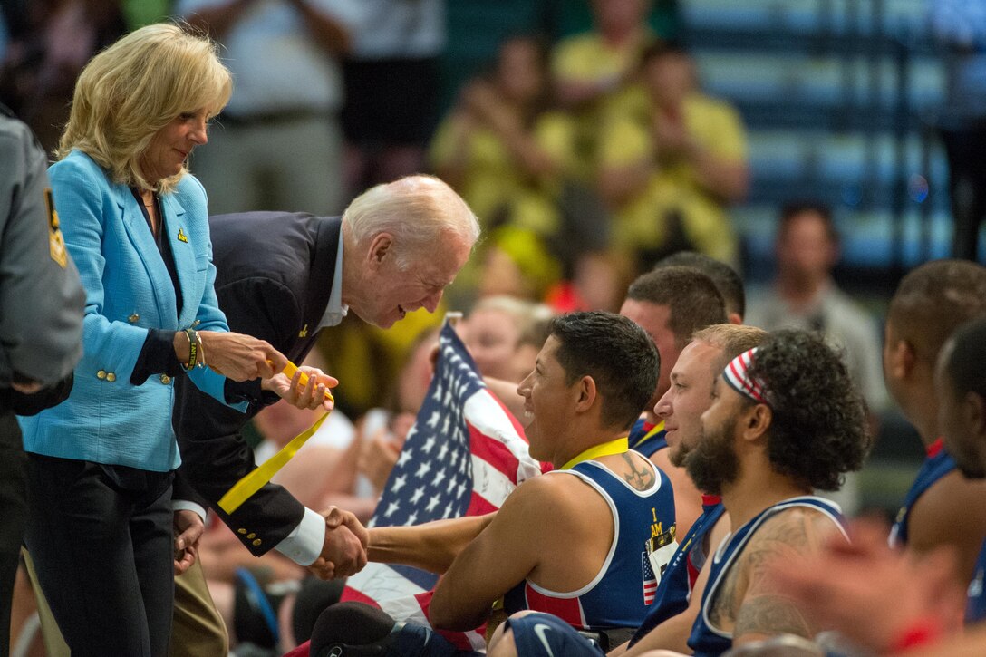 Vice President Joe Biden and his wife, Dr. Jill Biden, congratulate Marine Corps veteran Anthony Rios after presenting him with a gold medal following the U.S. victory against Denmark in wheelchair rugby at the 2016 Invictus Games in Orlando, Fla., May 11, 2016. DoD photo by Edward Joseph Hersom II