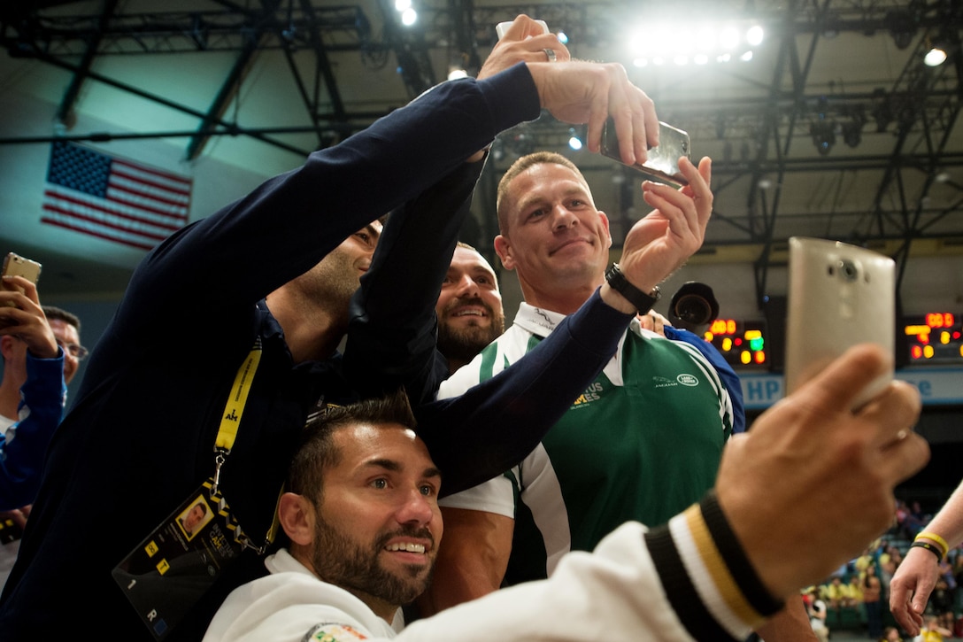 Members of the U.S. rugby team and spectators watching the wheelchair rugby match take selfies with wrestling superstar John Cena, right, during the 2016 Invictus Games in Orlando, Fla., May 11, 2016. DoD photo by Edward Joseph Hersom II