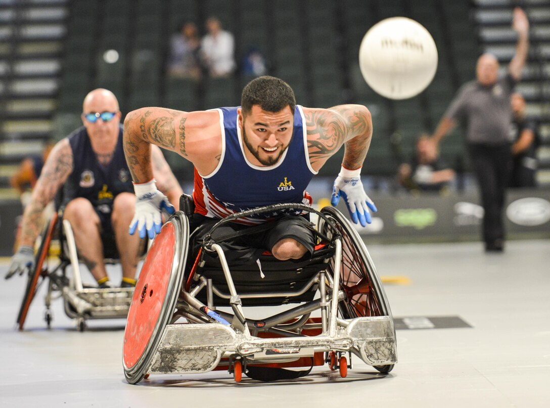 Marine Corps veteran Eric Rodriguez pushes the ball toward the goal and scores a point against the Australian team during a semifinal wheelchair rugby match at the 2016 Invictus Games in Orlando, Fla., May 11, 2016. Air Force photo by Senior Master Sgt. Kevin Wallace