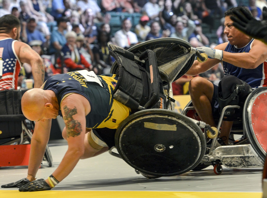 Australia’s Trent Serafini, left, flips in his wheelchair as a U.S. team member attempts to keep him upright during a semifinal wheelchair rugby match at the 2016 Invictus Games in Orlando, Fla., May 11, 2016. Air Force photo by Senior Master Sgt. Kevin Wallace