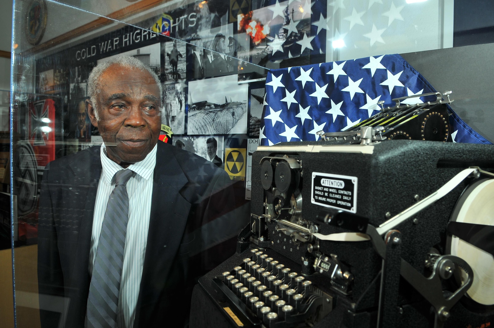 CMSgt (ret) Edward Jolly, Jr, peers through the plexiglass case at a WWII vintage SIGABA decoding machine in the AF ISR Agency Heritage Museum.  Jolly used a machine like this during his early years as cryptographic operator for the USAF Seurity Service in the 1950s.