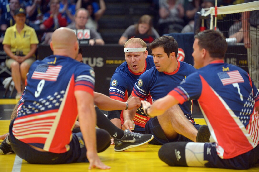 Members of the U.S. team huddle up after scoring a point in the sitting volleyball semifinals match at the 2016 Invictus Games in Orlando, Fla., May 10, 2016. Army photo by Staff Sgt. Alex Manne