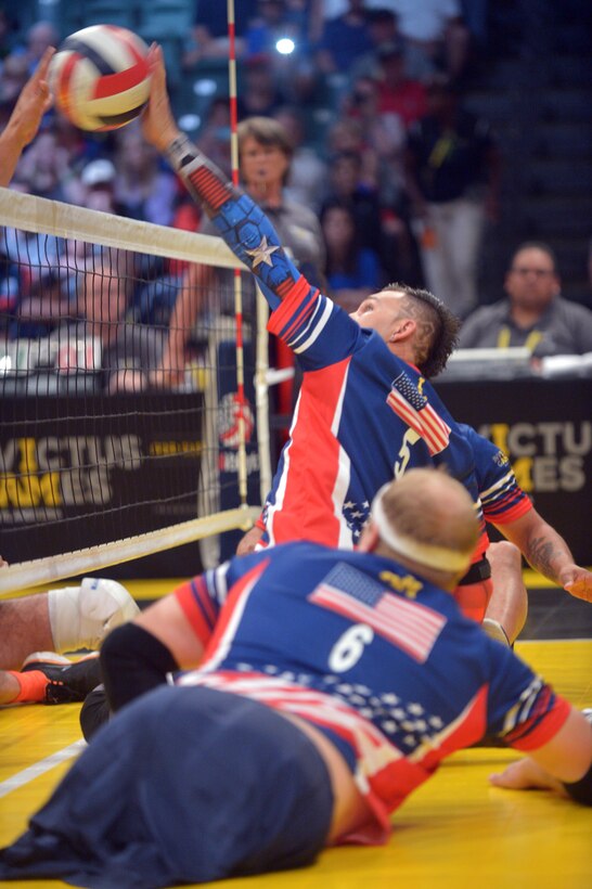 U.S. team member Robbie Gaupp spikes a ball over the net during the sitting volleyball semifinals match at the 2016 Invictus Games in Orlando, Fla., May 10, 2016. Army photo by Staff Sgt. Alex Manne
