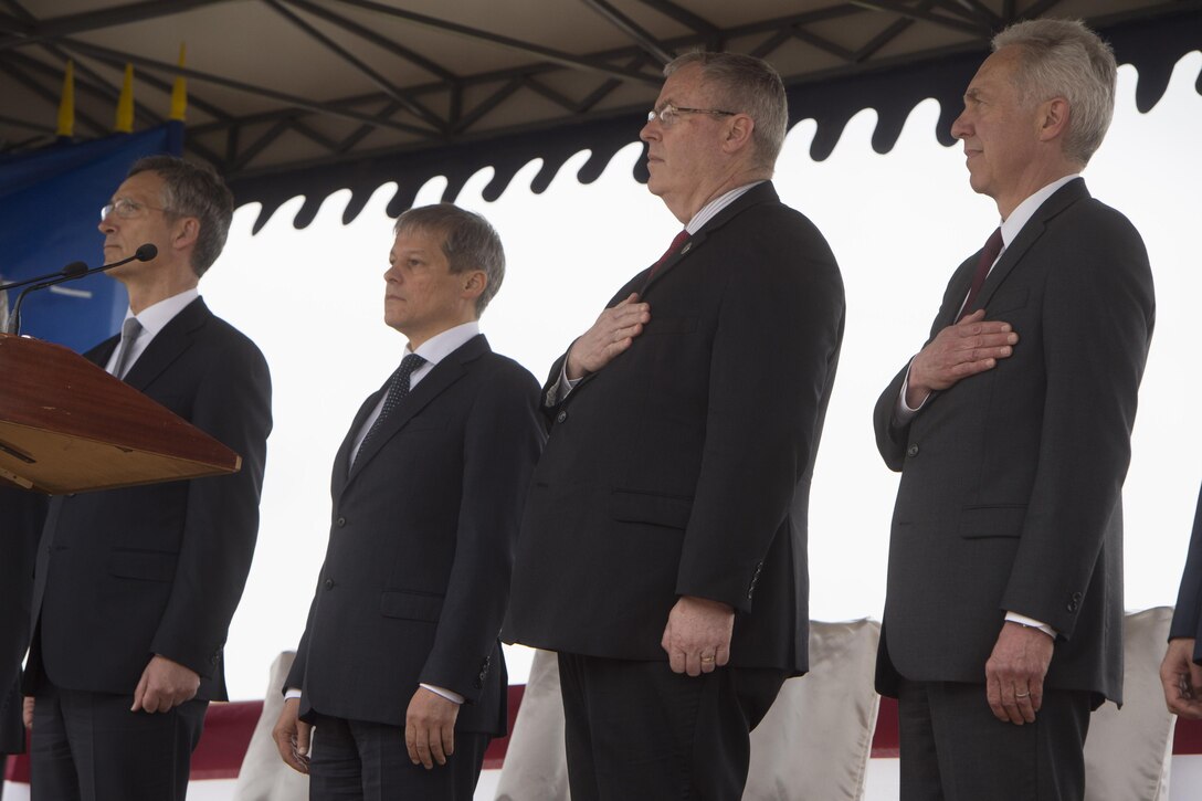 Deputy Defense Secretary Bob Work, second from right, observes the national anthem next to Romanian Prime Minister Dacian Ciolos, second from left, at the Aegis Ashore Inauguration Ceremony in Deveselu, Romania, May 12, 2016. DoD photo by Navy Petty Officer 1st Class Tim D. Godbee