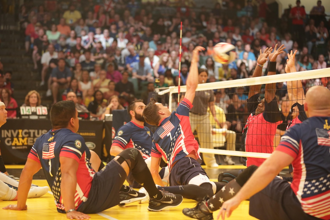 Army veteran Nicholas Titman, center, spikes the ball against the British team during the sitting volleyball gold medal finals match at the 2016 Invictus Games in Orlando, Fla., May 11, 2016. Army photo by Sgt. Jason Edwards