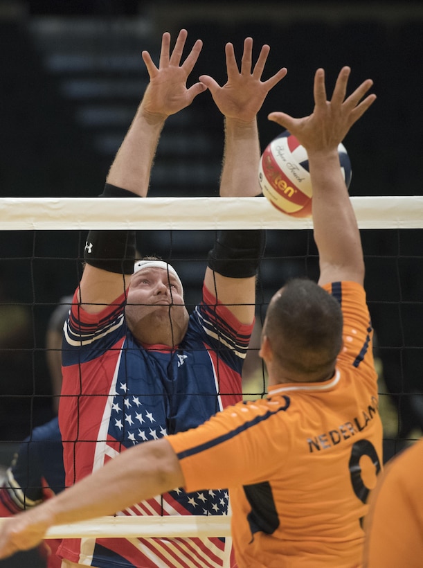 Marine Corps veteran Travis Greene prepares to block the ball against a Danish player in a sitting volleyball semifinals match at the 2016 Invictus Games in Orlando, Fla., May 11, 2016. DoD photo by Roger Wollenberg