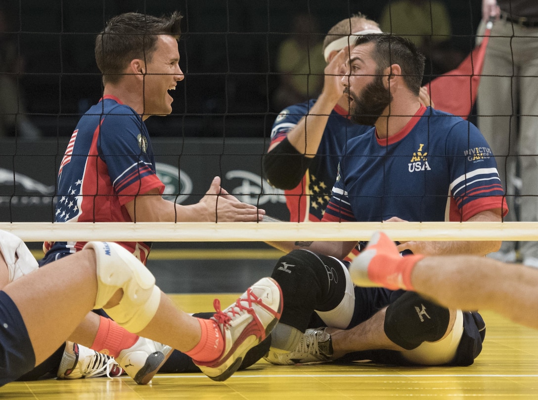 Army veteran Nicholas Titman, left, and Air Force veteran Nicholas Dadgostar celebrate after scoring a point against the Danish team in a sitting volleyball match at the 2016 Invictus Games in Orlando, Fla., May 11, 2016. DoD photo by Roger Wollenberg 