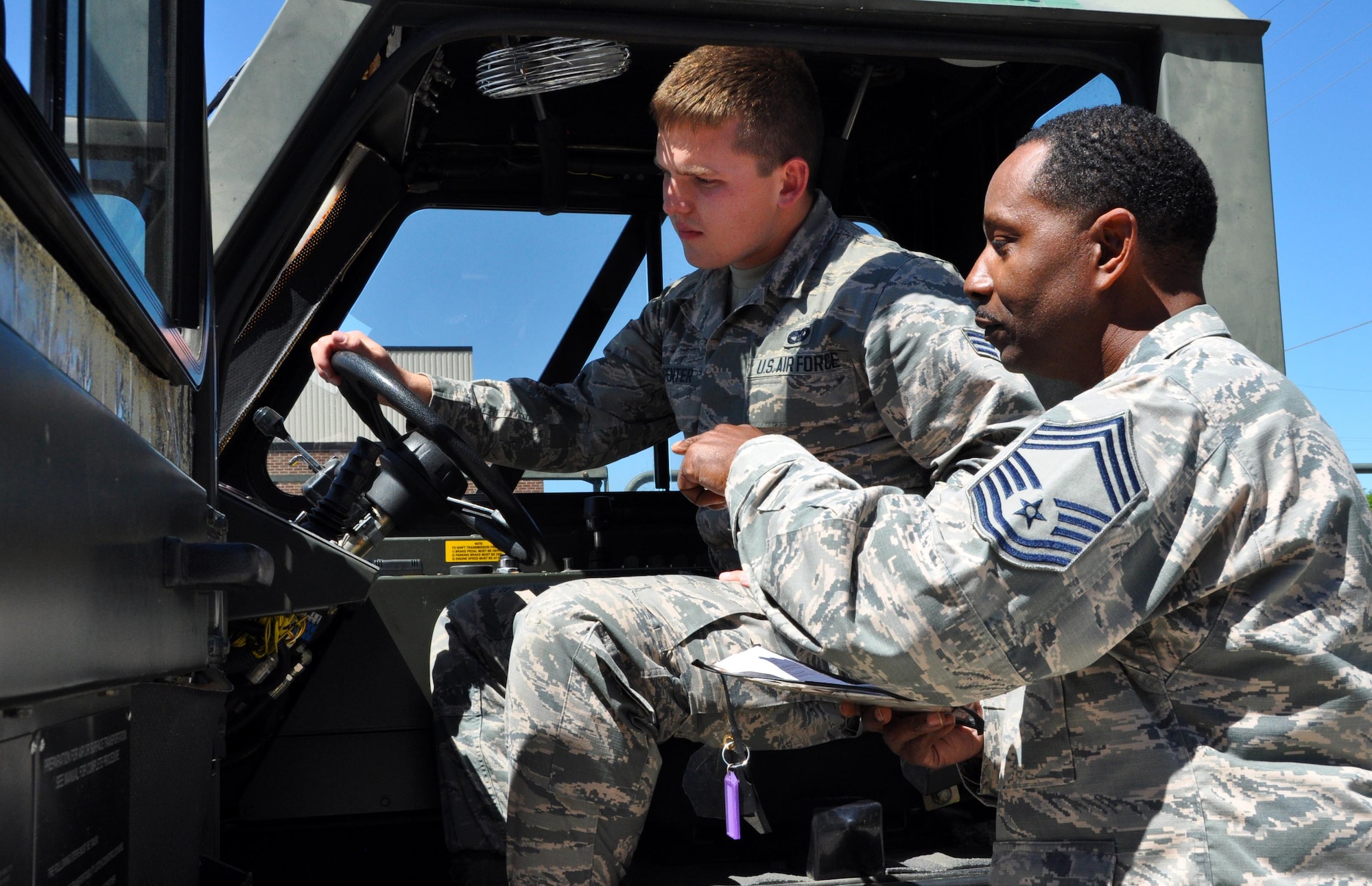 Chief Master Sgt. Lee Green, 80th Aerial Port Squadron cargo specialist, and Senior Airman Daniel Carpenter, 80th APS air transportation journeyman, review functions inside a K Loader, a series of loading truck used at Dobbins Air Reserve Base. Carpenter will be going to the Air Force Academy in July and many fellow Airmen say Carpenter has been preparing to be a pilot since he was very young. (U.S. Air Force photo by Senior Airman Lauren Douglas)