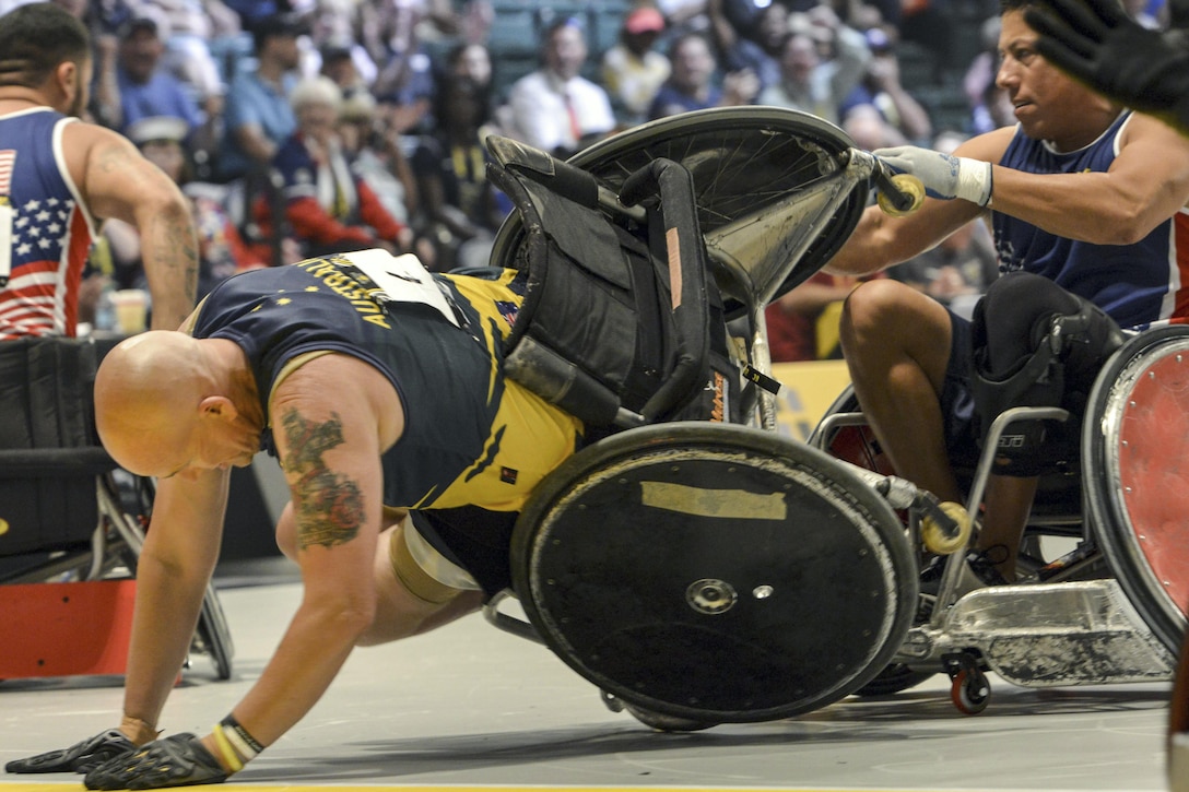 Australia’s Trent Serafini, left, flips in his wheel chair as a U.S. team member attempts to keep him upright during their semi-final wheelchair rugby match at the 2016 Invictus Games in Orlando, Fla., May 11, 2016. Air Force photo by Senior Master Sgt. Kevin Wallace