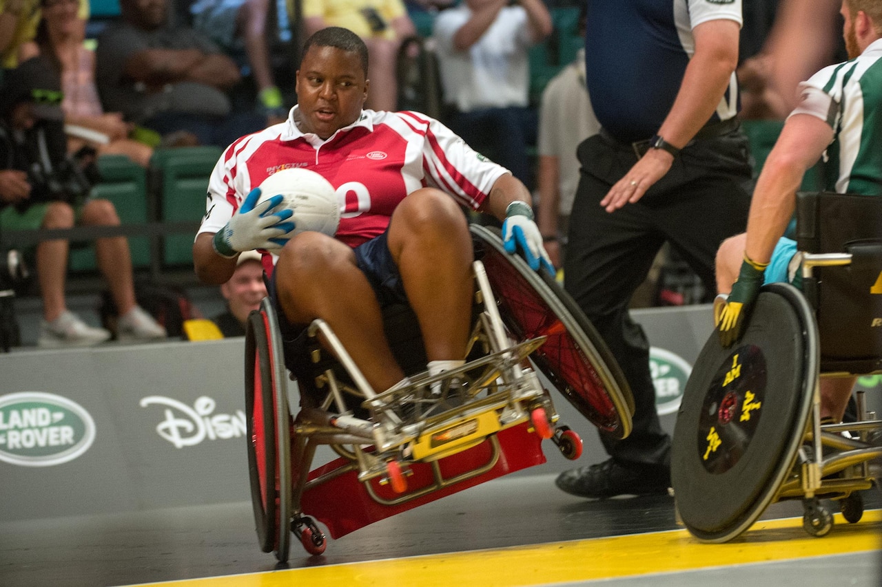 Medically retired Army Sgt. Monica Southall takes a hit while scoring in a wheelchair rugby exhibition match with celebrities in association with the 2016 Invictus Games in Orlando, Fla., May 11, 2016. DoD photo by EJ Hersom