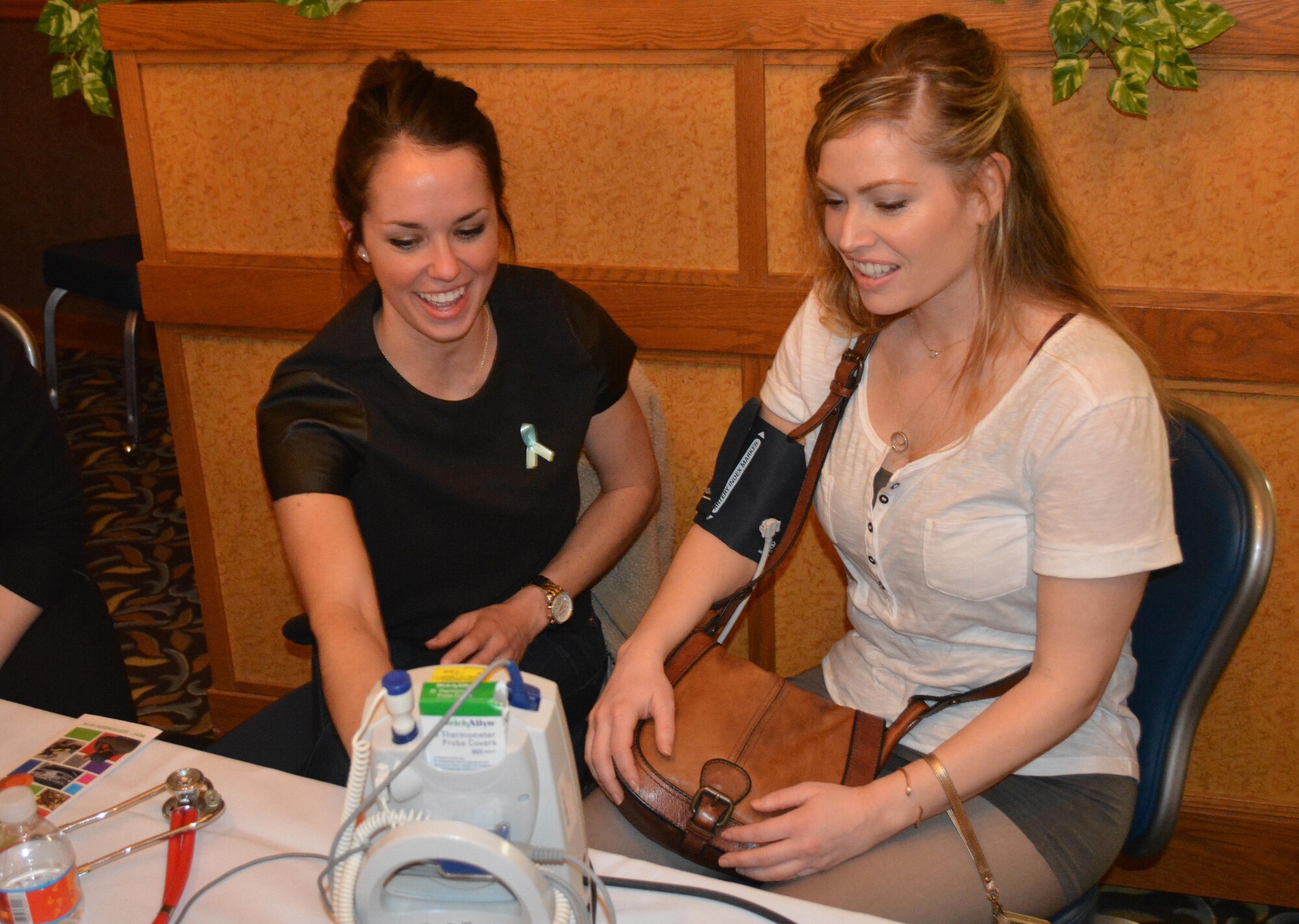 U.S. Air Force 1st Lt. Kelly Wheeler, a 354th Medical Group disease manager, assists an attendee of Ladies Night Out with a blood pressure check April 29, 2016, at Eielson Air Force Base, Alaska. Free blood pressure screenings were provided for the women as well as a free massage and manicure. (U.S. Air Force photo by Capt. Abigail Rose/Released)