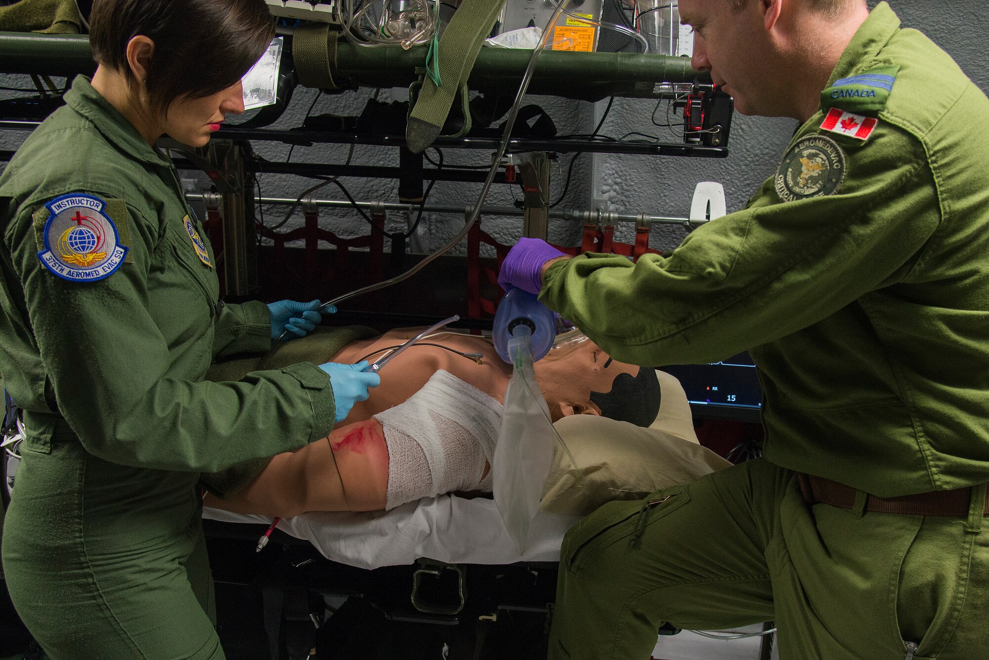 Capt. Damien Miller, 375th Aeromedical Evacuation Squadron flight nurse, provides rescue breaths to a simulated patient who is having difficulties breathing while Staff. Sgt. Dasha Ermanova is prepared to suction the patient if required on a new training simulator at Scott Air Force Base, Illinois on May 5, 2016. The Cargo Compartment Trainer comes equipped with new features including an upgraded camera and recording system which gives the ability to replay training scenarios and document trends. The 375th AES completed 117 missions in the year 2015. (U.S. Air Force Photo by Airman Daniel Garcia)