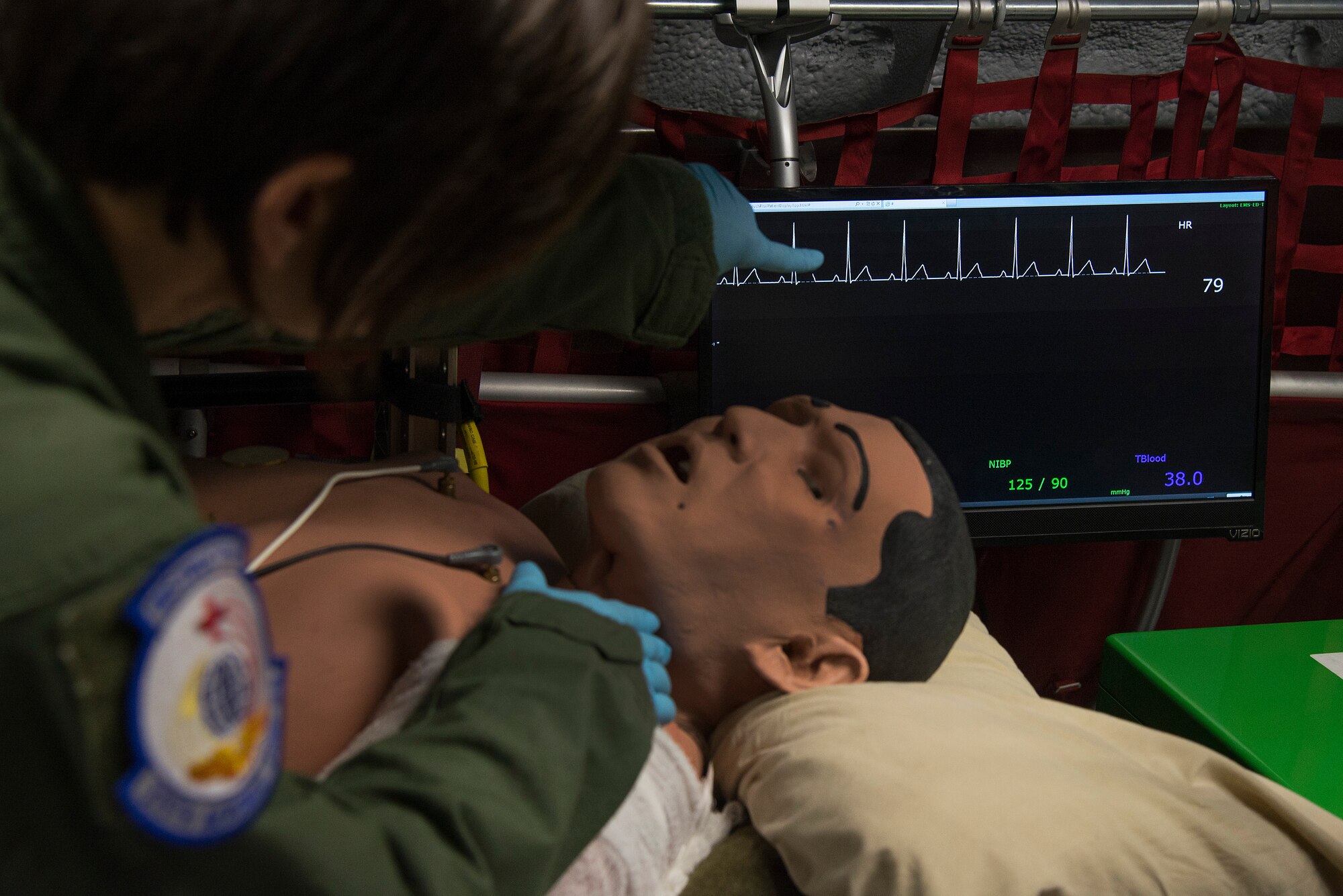 Staff Sgt. Dasha Ermanova, 375th Aeromedical Evacuation Squadron aeromedical evacuation technician, assess a simulated patient's responsiveness while comparing the results on a vitals monitor on a new training simulator at Scott Air Force Base, Illinois on May 5, 2015. The Cargo Compartment Trainer comes equipped with new features including an upgraded camera and recording system which gives the ability to replay training scenarios and document trends. (U.S. Air Force Photo by Airman Daniel Garcia)