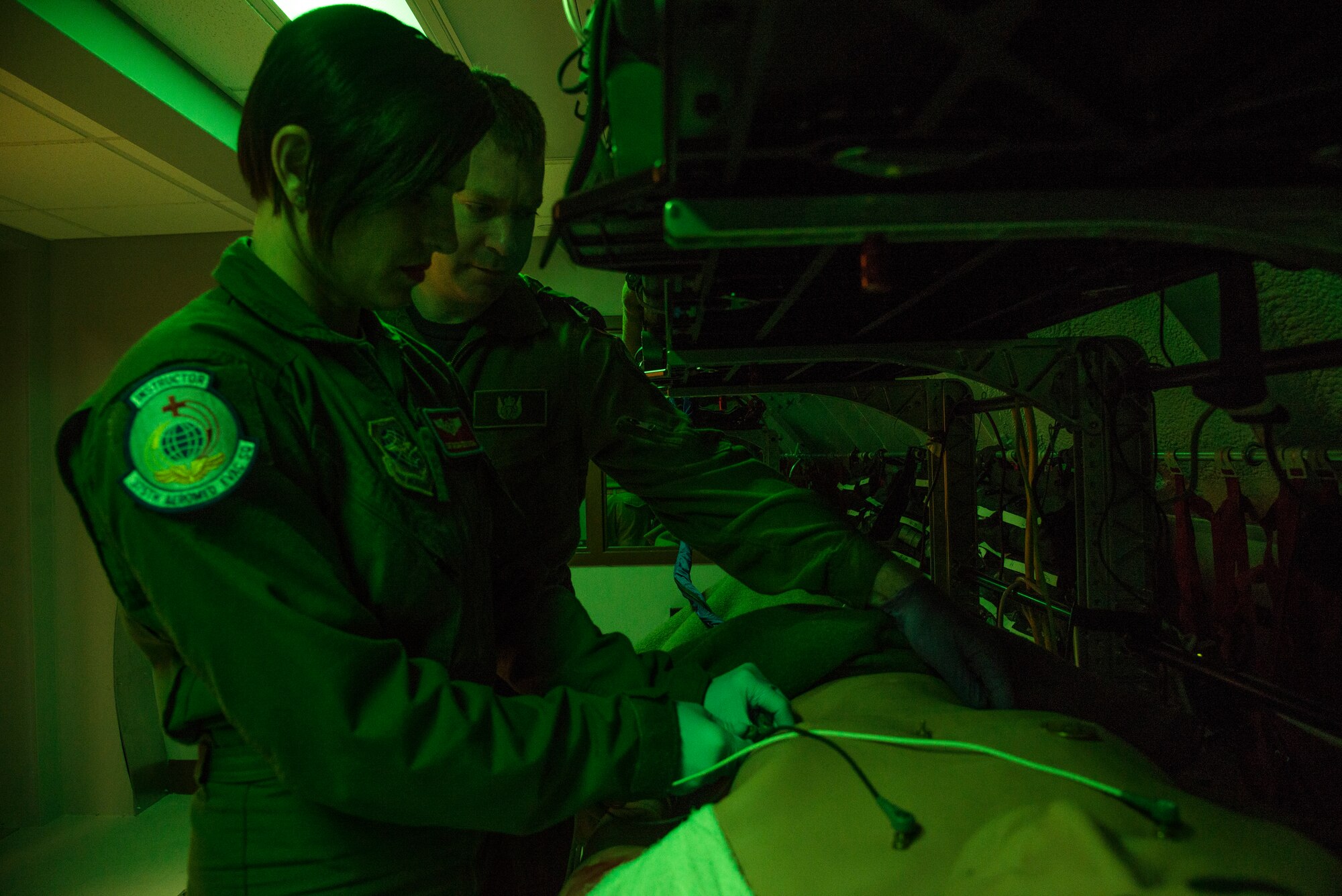 Staff Sgt. Dasha Ermanova, 375th Aeromedical Evacuation Squadron aeromedical evacuation technician, and Captain Damien Miller, 375th Aeromedical Evacuation Squadron flight nurse attach ECG leads to a simulated patient in order to assess the electrical activity of the patients heart on a new training simulator at Scott Air Force Base, Illinois on May 5, 2015. The Cargo Compartment Trainer comes equipped with new features including an upgraded camera and recording system which gives the ability to replay training scenarios and document trends. (U.S. Air Force Photo by Airman Daniel Garcia)