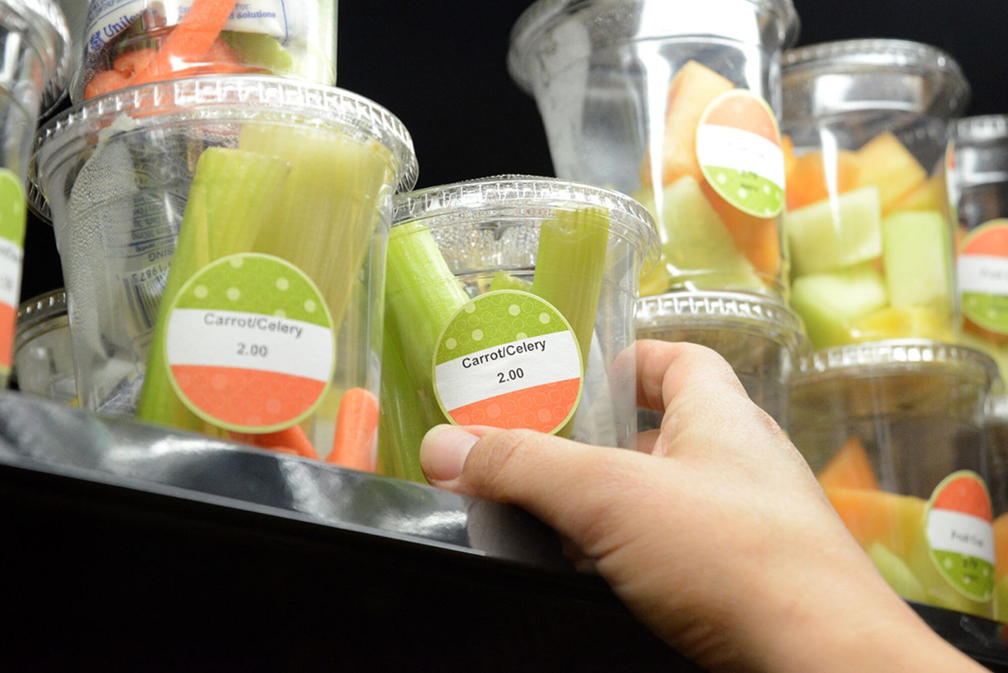 A customer retrieves a container of carrots and celery at the Provisions on Demand, Joint Base Elmendorf-Richardson, Alaska, May 6, 2016. The POD was created through the Food Transformation Initiative intended to supply Airmen with more and healthier options similar to campus-style dining. (U.S. Air Force photo by Airman Christopher R. Morales)